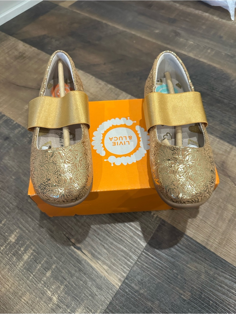 Livie & Luca Girls' Metallic Gold Embossed Mary Janes with Bow Strap
